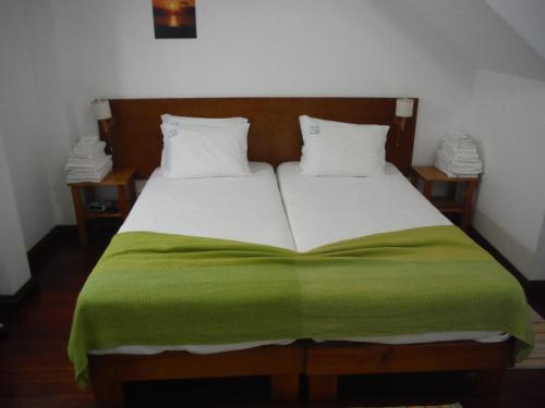 1 cama con manta verde y 2 mesitas de noche en Quinta Da Ribeira Da Urze, en Prainha de Cima