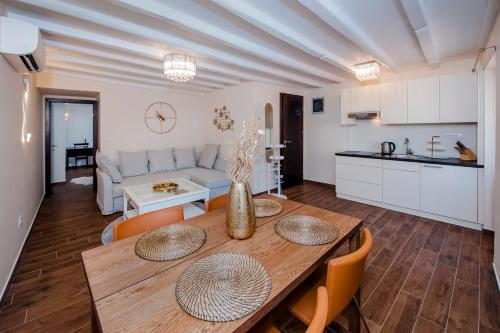 eine Küche und ein Wohnzimmer mit einem Holztisch und Stühlen in der Unterkunft Villa Nea in Rovinj