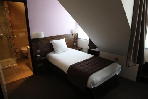 ブザンソンにあるホテル ヴォーバンの小さなベッドルーム(ベッド1台、シャワー付)