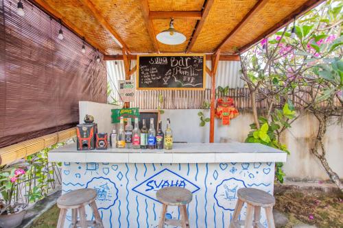 a bar with two stools and a chalk board at Svaha Private Villas Ceningan in Nusa Lembongan