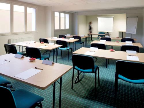 an empty classroom with tables and chairs at ibis Tarbes Odos in Odos