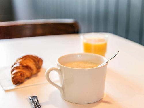 a cup of coffee and a glass of orange juice at ibis Falaise Coeur de Normandie in Falaise