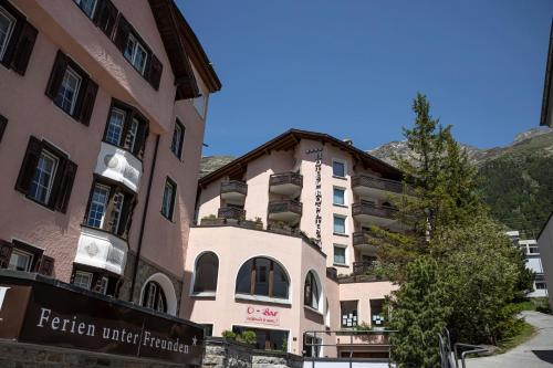 a hotel in the mountains next to a building at Hotel Rosatsch in Pontresina