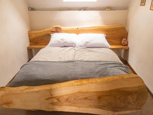 a bedroom with a wooden bed with two pillows at Bajeczny domek Andrzejówka in Polańczyk