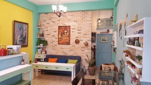 ein Wohnzimmer mit einer Couch und einer Ziegelwand in der Unterkunft Lillian B&B in Tainan