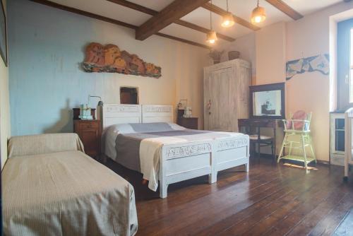 a bedroom with two beds and a table and a desk at B&B Terre e Colori in Sant'Olcese