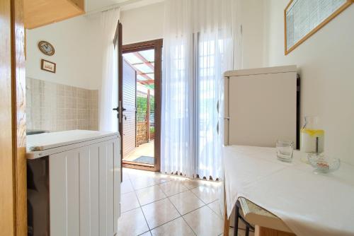 uma cozinha com um balcão branco e um lavatório em Apartments Loncar em Krk