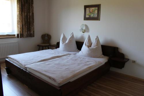 Schlafzimmer mit einem Bett mit weißer Bettwäsche und Kissen in der Unterkunft Apartment-Kraft in Lungötz