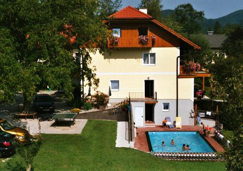 una casa con piscina frente a ella en Frühstückpension Haus Helene, en Schörfling am Attersee