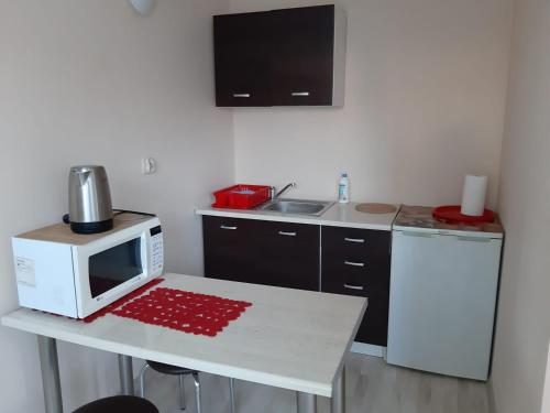 uma cozinha com uma mesa e um micro-ondas em Apartament u Basi em Gdansk