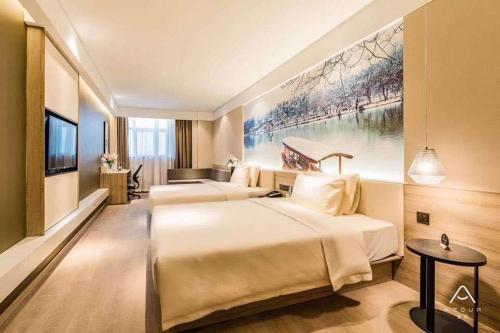 a hotel room with two beds and a painting on the wall at Atour Hotel Yangzhou Ancient Canal Dongguan Street in Yangzhou