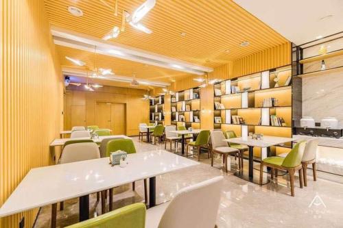 a restaurant with tables and chairs and yellow walls at Atour Hotel Yangzhou Ancient Canal Dongguan Street in Yangzhou