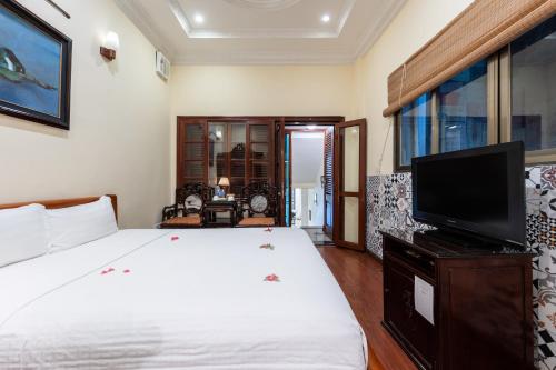 a bedroom with a bed and a flat screen tv at Hanoi Little Town Hotel in Hanoi