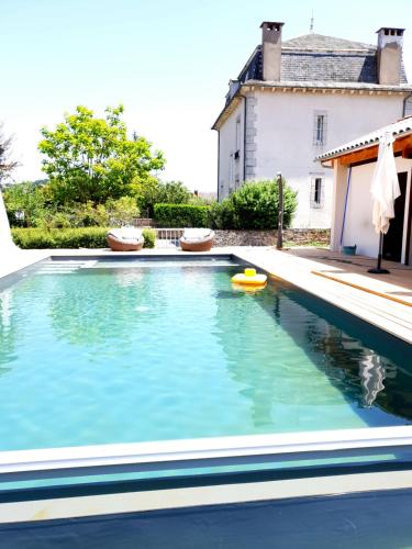 a swimming pool in front of a house at La Martinelle in Maurs