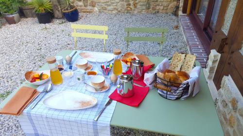 a picnic table with food and bread on it at L'Herbe aux Vaches in Saint-Pierre-Azif