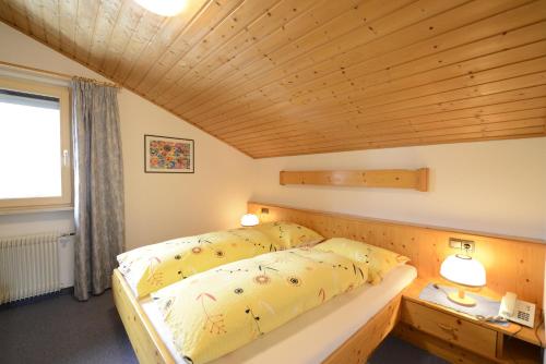 - une chambre avec un lit et un plafond en bois dans l'établissement Residence Badleit, à Lagundo