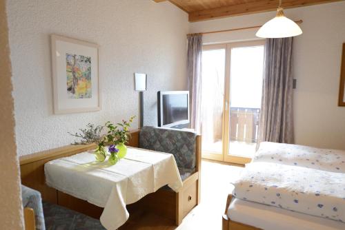 une chambre d'hôtel avec une table, un lit et une fenêtre dans l'établissement Residence Badleit, à Lagundo