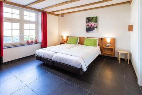 1 dormitorio con 1 cama grande con almohadas verdes en Spraelandhof, en Oostrum