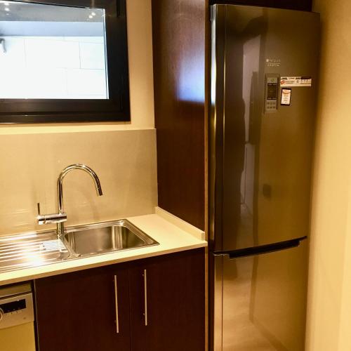 a kitchen with a stainless steel refrigerator and a sink at Duplex Carma in L'Ametlla de Mar