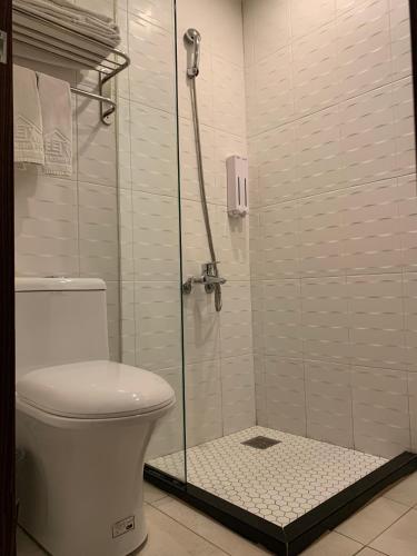 a bathroom with a toilet and a glass shower at Skyone Hotel in Kaohsiung