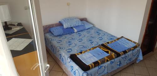 a small bed with two blue pillows on it at Apartments Draga in Budva