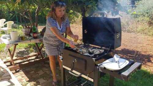 a woman is cooking food on a grill at Clara 2 in Poreč