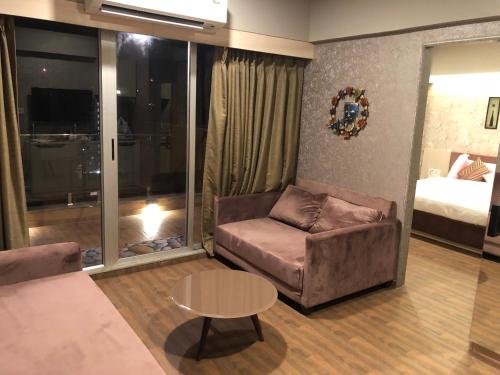 a living room with a couch and a table and a bed at WEEKEND ADDRESS PRIVATE SUITE Room in Surat