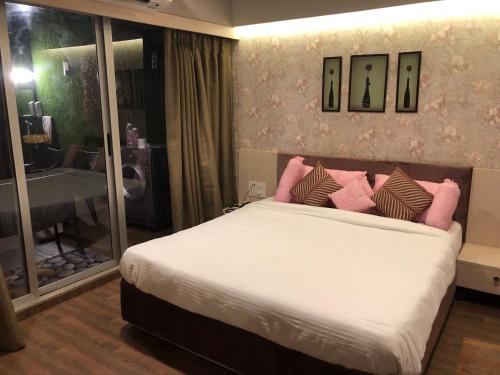 a bedroom with a large bed with pink pillows at WEEKEND ADDRESS PRIVATE SUITE Room in Surat