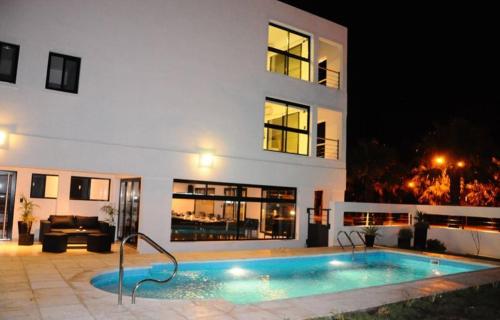 a swimming pool in front of a building at night at Andaluhe Posada in Miramar