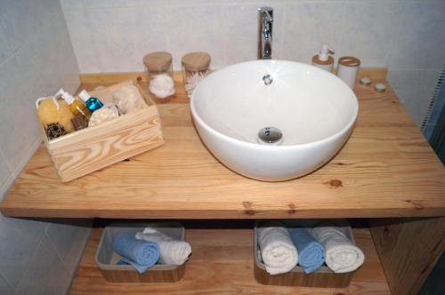 a bathroom counter with a sink and towels at Les Agapanthes du frontonnais in Bouloc