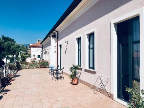 a patio with chairs and tables on the side of a building at Casa del Marchese B&B in Riposto