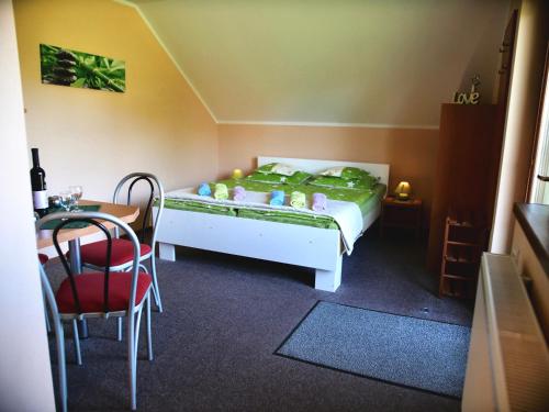 sypialnia z łóżkiem, stołem i krzesłami w obiekcie Apartmány u Slavky w Beszeniowej