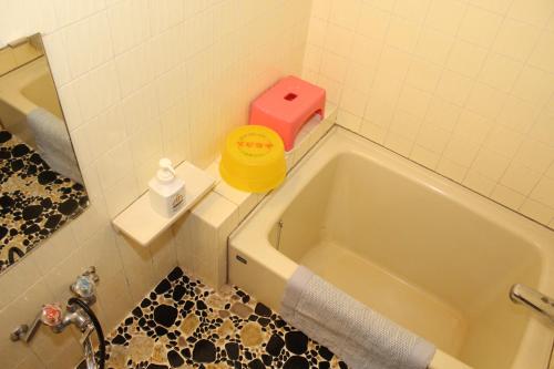 a bathroom with a bath tub and a pink box at Takahan in Yuzawa