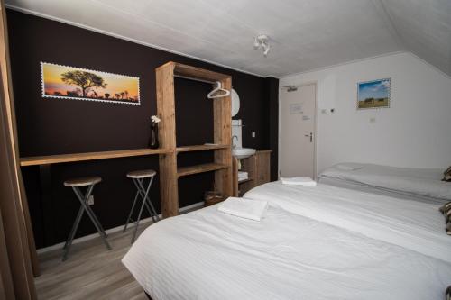 a hotel room with two beds and a bathroom at B&B Aangenaam - Olde Horst Diever in Diever