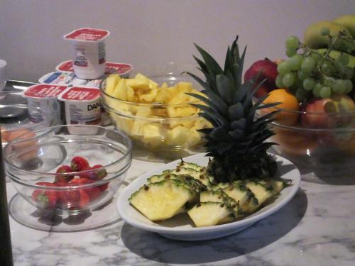 a plate with a pineapple on a table with fruit at Hotel Monarc in Ostend