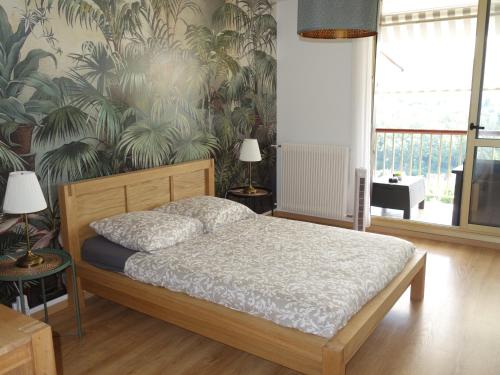 a bedroom with a bed and a wall with plants at 2 Pieces proche Beauval et Châteaux in Montrichard