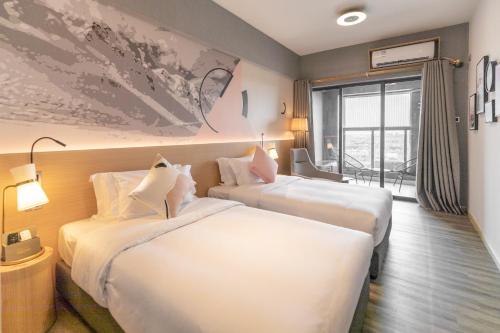 een hotelkamer met 2 bedden en een raam bij Imin Hotel in Huadu