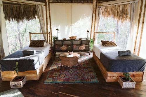 Dreamsea Surf Resort Nicaragua في سان خوان ديل سور: سريرين في غرفة بها نوافذ