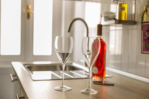 two wine glasses sitting on top of a kitchen counter at Il Cedrangolo House in Monopoli