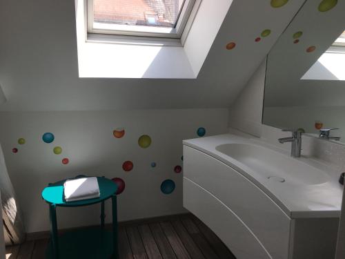 een badkamer met een bad, een wastafel en een raam bij Loft P'tite Pomme Azay le Rideau in Azay-le-Rideau