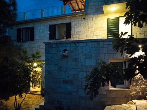 a brick building with a person sitting on the side of it at Villa Ujoli in Splitska