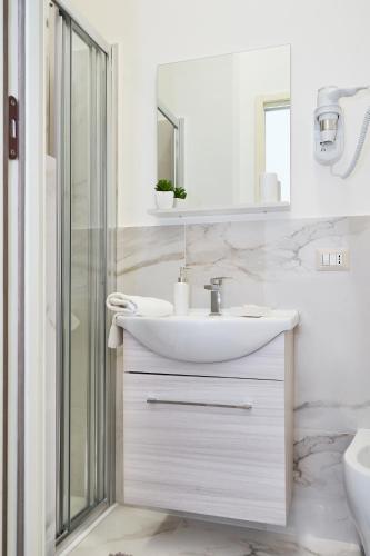 a white bathroom with a sink and a shower at Dimora Casanello in Lecce