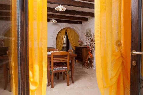 a dining room with a table and a yellow curtain at Da Santino in Alberobello