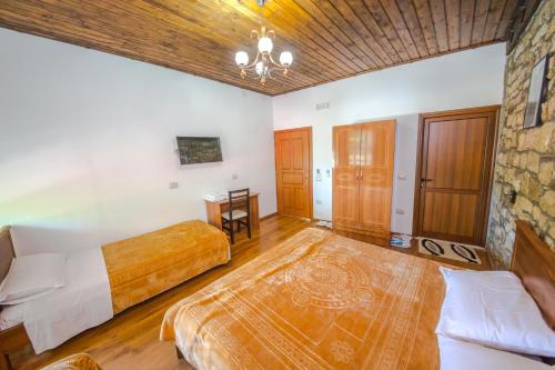 a bedroom with two beds and a wooden ceiling at Hotel Kalaja in Berat