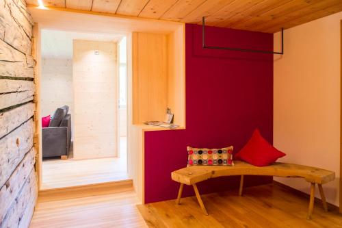 a room with a bench and a red wall at Appartement Omeshorn anno 1593 in Lech am Arlberg