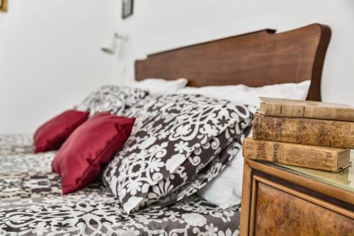 a bed with black and white sheets and red pillows at Il Cedrangolo House in Monopoli