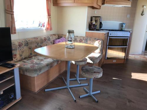 a kitchen with a table and a couch and a table at Caravanverhuur Zeeland in Wemeldinge