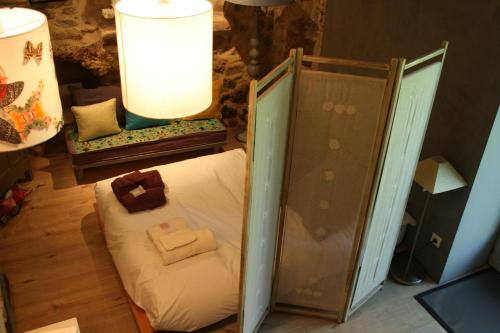 a small bed in a room with a lamp at Le domaine des rouges queues in Châteaudouble