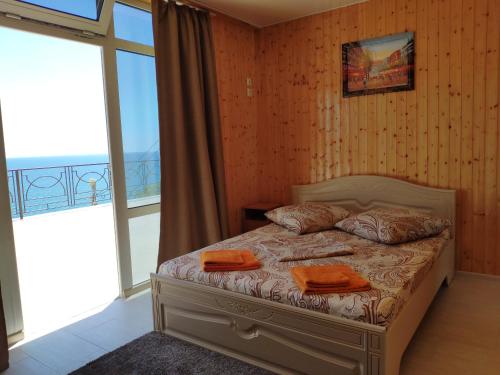 a bedroom with a bed with orange towels on it at Guest House Panorama in Malorechenskoye