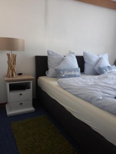 una camera da letto con un letto e un comodino con una lampada di Rathausschenke Münstermaifeld a Münstermaifeld